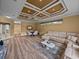 Spacious living room with unique ceiling design, seamlessly connecting the living and dining areas at 12413 Woodlands Cir, Dade City, FL 33525