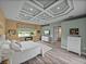 Serene primary bedroom featuring decorative ceilings, wood floors, and a cozy fireplace at 12413 Woodlands Cir, Dade City, FL 33525