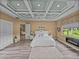 Spacious primary bedroom featuring tray ceiling, wood flooring, fireplace, and seamless flow at 12413 Woodlands Cir, Dade City, FL 33525