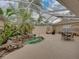 Enclosed patio with small pool, multiple seating areas, and tropical plants at 12413 Woodlands Cir, Dade City, FL 33525