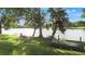Tranquil lakeside backyard features mature trees, a fire pit, picnic table, and a small boat at 1313 Oxbridge Dr, Lutz, FL 33549