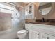 Neutral bathroom with a glass-enclosed shower/tub combo, white vanity, and a granite countertop at 1313 Oxbridge Dr, Lutz, FL 33549