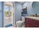 Bathroom with a vanity with countertop, a round mirror, blue walls and access to the pool at 1313 Oxbridge Dr, Lutz, FL 33549