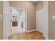 Hallway leading to a well-lit bathroom with tiled floors and an open doorway at 1313 Oxbridge Dr, Lutz, FL 33549