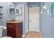 Bathroom with a vanity with countertop, a round mirror and blue walls at 1313 Oxbridge Dr, Lutz, FL 33549
