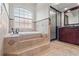 Bathroom showcases a jacuzzi tub, a glass-enclosed shower, and elegant tile work at 1313 Oxbridge Dr, Lutz, FL 33549