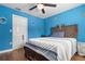 A bedroom features bright blue walls, a ceiling fan, and hardwood floors at 1313 Oxbridge Dr, Lutz, FL 33549