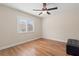 Bedroom with hardwood floors, window with shutters, and a ceiling fan with light at 1313 Oxbridge Dr, Lutz, FL 33549