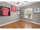 Bright bedroom with hardwood floors, framed sports memorabilia, plantation shutters, and neutral paint at 1313 Oxbridge Dr, Lutz, FL 33549