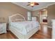 Comfortable bedroom features a ceiling fan, hardwood floors, and neutral decor with access to the bathroom at 1313 Oxbridge Dr, Lutz, FL 33549