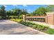 Entrance to The Lakes of Wellington with brick signage and lush landscaping at 1313 Oxbridge Dr, Lutz, FL 33549