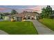 Beautiful home exterior with a long driveway, lush green lawn, and well-manicured landscaping at 1313 Oxbridge Dr, Lutz, FL 33549