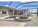 Screened-in pool area with spa and outdoor dining furniture overlooking the lake at 1313 Oxbridge Dr, Lutz, FL 33549
