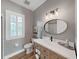 Bathroom featuring gray walls, natural wood vanity with sink, and window with shutter at 15024 Eaglepark Pl, Lithia, FL 33547