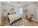 Bright bedroom with a gray platform bed, wood floors, and classic rocking chair at 15024 Eaglepark Pl, Lithia, FL 33547