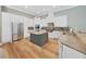 Open kitchen with white cabinets, stainless appliances, granite countertops, and a gray kitchen island at 15024 Eaglepark Pl, Lithia, FL 33547