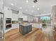 A kitchen with white cabinets, stainless appliances, an island, and a view into the living room at 15024 Eaglepark Pl, Lithia, FL 33547