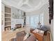 This living room features a stone fireplace, hardwood floors, white shelving, and a trey ceiling at 15024 Eaglepark Pl, Lithia, FL 33547
