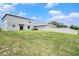 Expansive backyard with a modern two-story house, white fence, and lush green grass at 1655 Blue Rose Dr, Ruskin, FL 33570