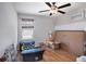 Bedroom featuring a ceiling fan, window with blinds, and ample storage boxes at 1655 Blue Rose Dr, Ruskin, FL 33570