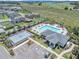 Aerial view of community amenities featuring a pool, clubhouse, basketball court, and ample parking at 1655 Blue Rose Dr, Ruskin, FL 33570
