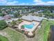 Aerial view of a sparkling community pool surrounded by lush landscaping and a clubhouse at 1655 Blue Rose Dr, Ruskin, FL 33570