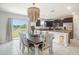 Open kitchen and dining area with elegant chandelier and lake view sliding doors at 1655 Blue Rose Dr, Ruskin, FL 33570