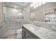 Modern bathroom with tiled shower, marble countertops, updated fixtures, and lots of lighting at 1660 Cape Ann Ne Ave # 2, St Petersburg, FL 33702