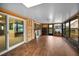 Spacious sunroom with wood-look floors, walls with light colored trim, and glass doors at 1660 Cape Ann Ne Ave # 2, St Petersburg, FL 33702