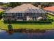 Aerial view of a home with a large screened patio, a gorgeous pool, and a tranquil water view at 17921 Arbor Haven Dr, Tampa, FL 33647