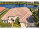 Aerial view of home with tile roof, lush landscaping, and a serene lake view at 17921 Arbor Haven Dr, Tampa, FL 33647