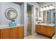 Bright bathroom featuring double sinks, glass shower, and stylish round mirror at 17921 Arbor Haven Dr, Tampa, FL 33647