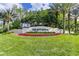 Inviting Arbor Greene community entrance featuring lush landscaping, colorful flower beds, and mature palms at 17921 Arbor Haven Dr, Tampa, FL 33647