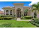 Charming home exterior with manicured lawn, lush landscaping, and arched entryway at 17921 Arbor Haven Dr, Tampa, FL 33647