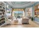 Cozy living room featuring a fireplace, built-in bookshelves, and outdoor views at 17921 Arbor Haven Dr, Tampa, FL 33647