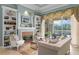 Comfortable living room featuring a fireplace, built-in bookshelves, and pool views at 17921 Arbor Haven Dr, Tampa, FL 33647