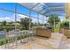 Outdoor kitchen featuring stone counters, stainless steel appliances, and views of the tranquil pond beyond the lanai at 17921 Arbor Haven Dr, Tampa, FL 33647