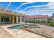 Enclosed pool featuring a spa with rock waterfall feature and overlooking the backyard patio with outdoor furniture at 17921 Arbor Haven Dr, Tampa, FL 33647