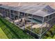 Aerial view of screened in patio with a luxurious pool, spa, outdoor furniture, and gorgeous landscaping at 17921 Arbor Haven Dr, Tampa, FL 33647