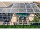 Aerial view of screened in patio with a luxurious pool, spa, outdoor furniture, and lush landscaping at 17921 Arbor Haven Dr, Tampa, FL 33647