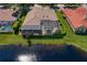 Aerial view of a well-maintained home featuring a screened-in lanai, pond, and lush green lawn at 17921 Arbor Haven Dr, Tampa, FL 33647
