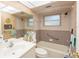 Well-lit bathroom featuring neutral colored tile, a shower-tub combo, and a vanity with ample counter space at 1808 Elmwood Dr, Oldsmar, FL 34677