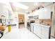 Bright kitchen featuring white cabinets, a skylight, and stainless steel appliances and white tile flooring at 1808 Elmwood Dr, Oldsmar, FL 34677