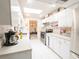 Functional kitchen with white cabinetry, stainless steel appliances, and bright tile flooring at 1808 Elmwood Dr, Oldsmar, FL 34677