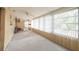 Enclosed sun room featuring paneled walls, carpeted flooring, and many large windows offering ample natural light at 1808 Elmwood Dr, Oldsmar, FL 34677