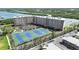 Aerial view of condo complex with tennis courts, landscaping, and a waterway view at 19451 Gulf Blvd # 205, Indian Shores, FL 33785