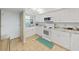 Bright kitchen with white cabinets, tiled floor, and white appliances at 19451 Gulf Blvd # 205, Indian Shores, FL 33785