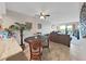 Open concept living room boasts tile floors, ceiling fan and balcony access with a view of lush landscaping at 19451 Gulf Blvd # 205, Indian Shores, FL 33785