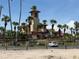 Exterior of Smugglers Cove Adventure Golf, featuring a large tower and tropical landscaping at 19451 Gulf Blvd # 205, Indian Shores, FL 33785