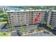 Exterior shot of condo building showing parking, palms, and bay views at 19451 Gulf Blvd # 205, Indian Shores, FL 33785